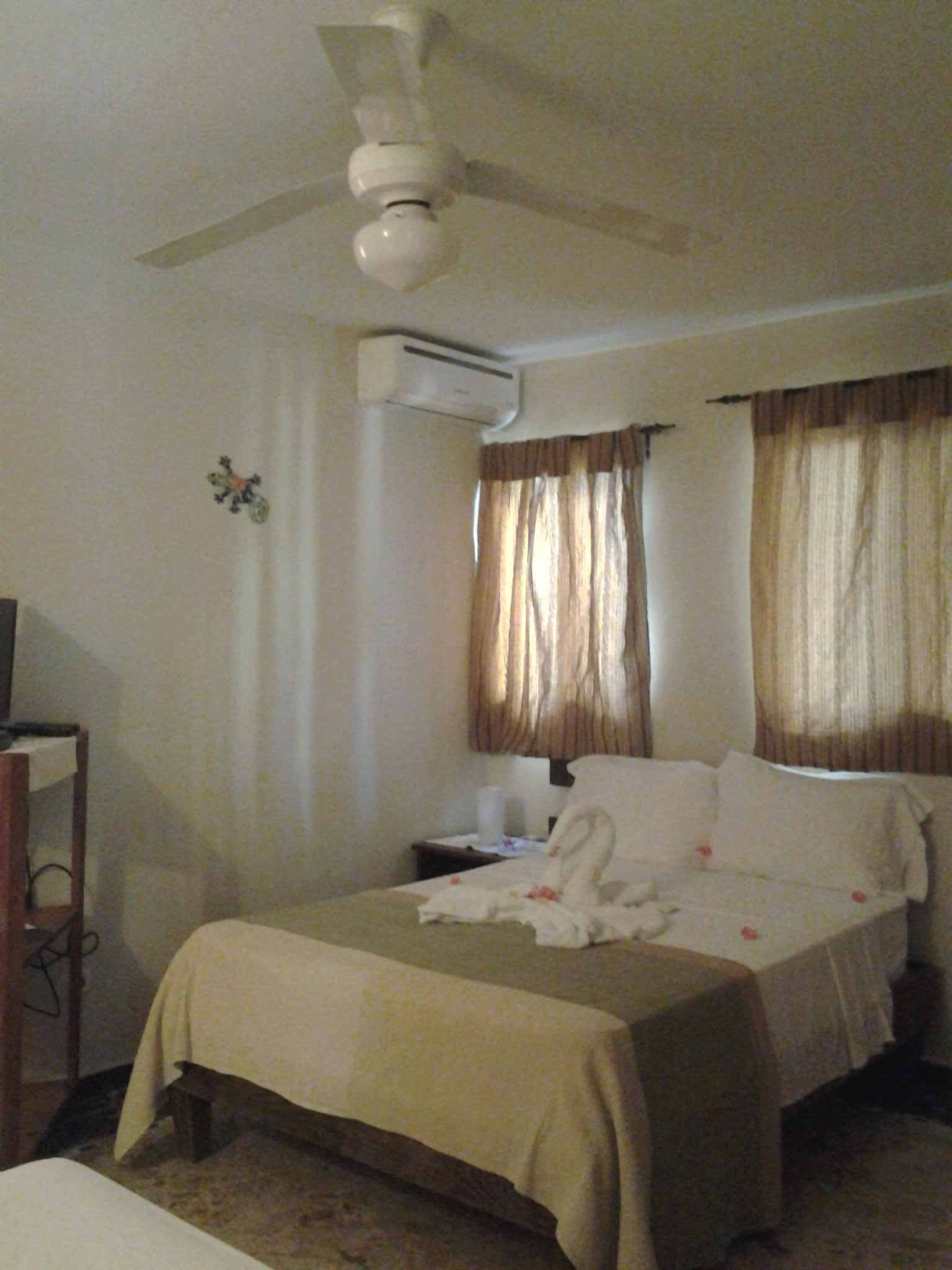 Bright bedroom with a double bed, curtains and air conditioning